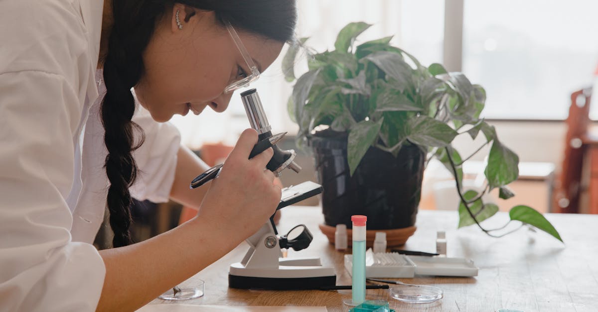 Scientist in lab examining recreated ancient cannabis enzymes under microscope