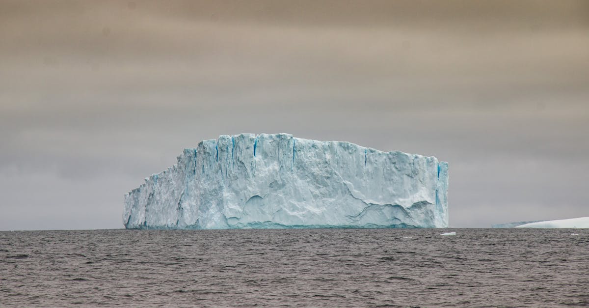 Satellite view of Antarctic ice shelf with visible cracks and calving icebergs in the Weddell Sea
