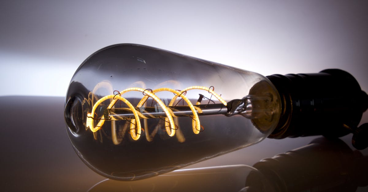 Closeup of Thomas Edison's 1879 carbon filament light bulb with glowing filament