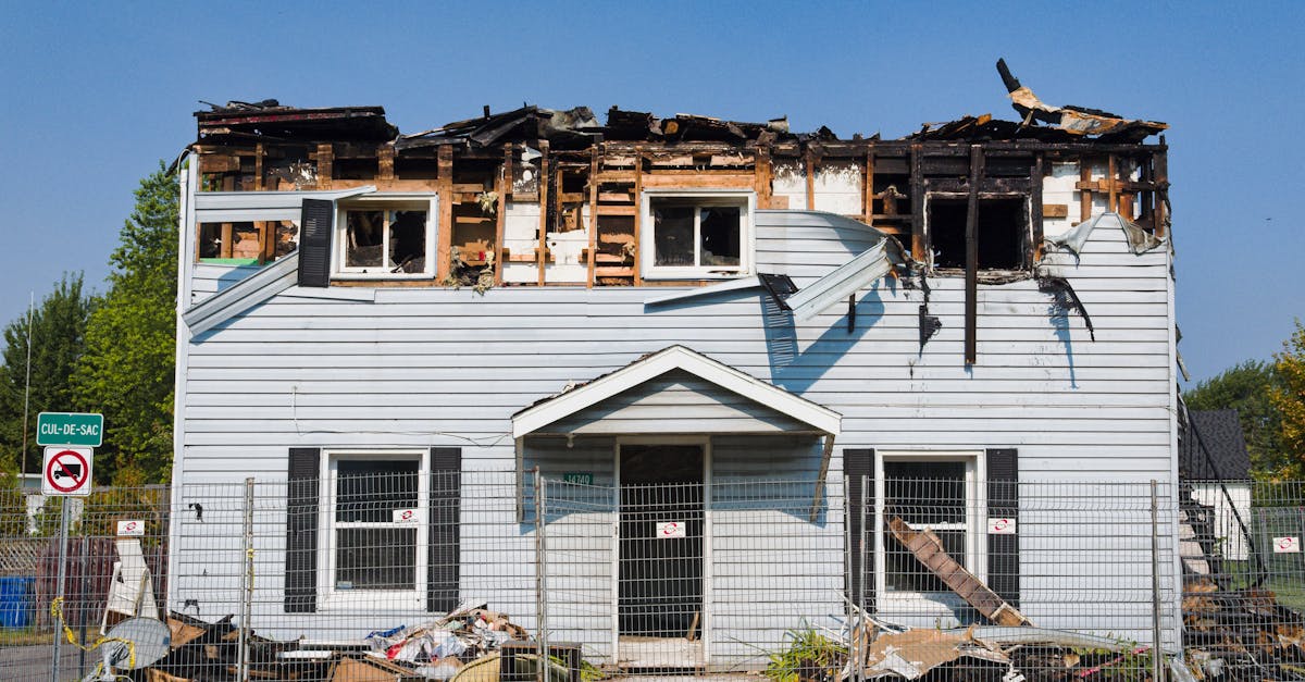 A person standing on the ground looking up at a residential roof that appears to need repair or replacement