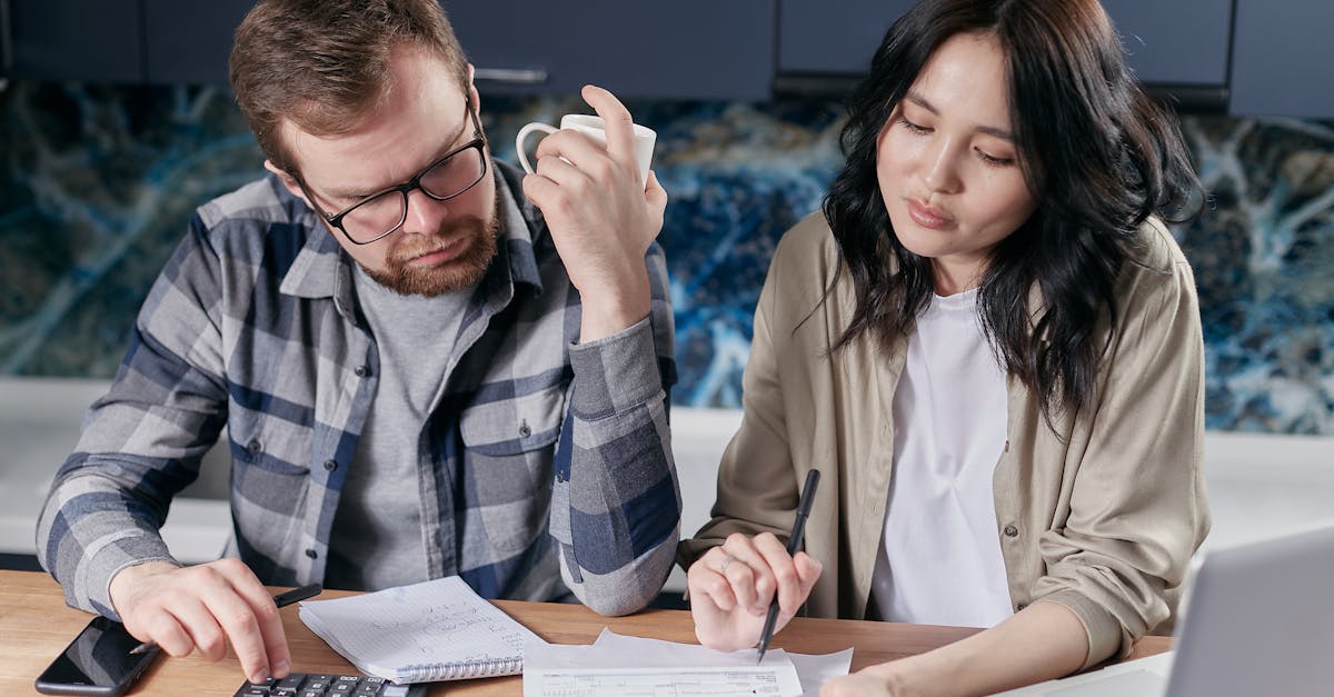 Retired couple sitting at table looking at budget papers and calculator