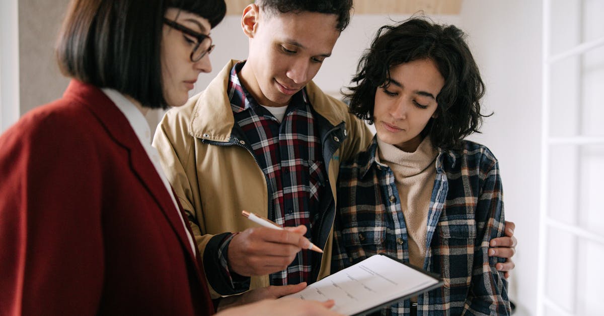 An older couple sits with a lawyer reviewing estate planning documents at a desk
