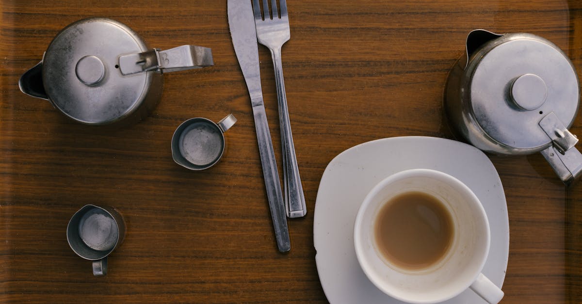 A bonobo sits at a table during a pretend tea party experiment with transparent cups and pitcher