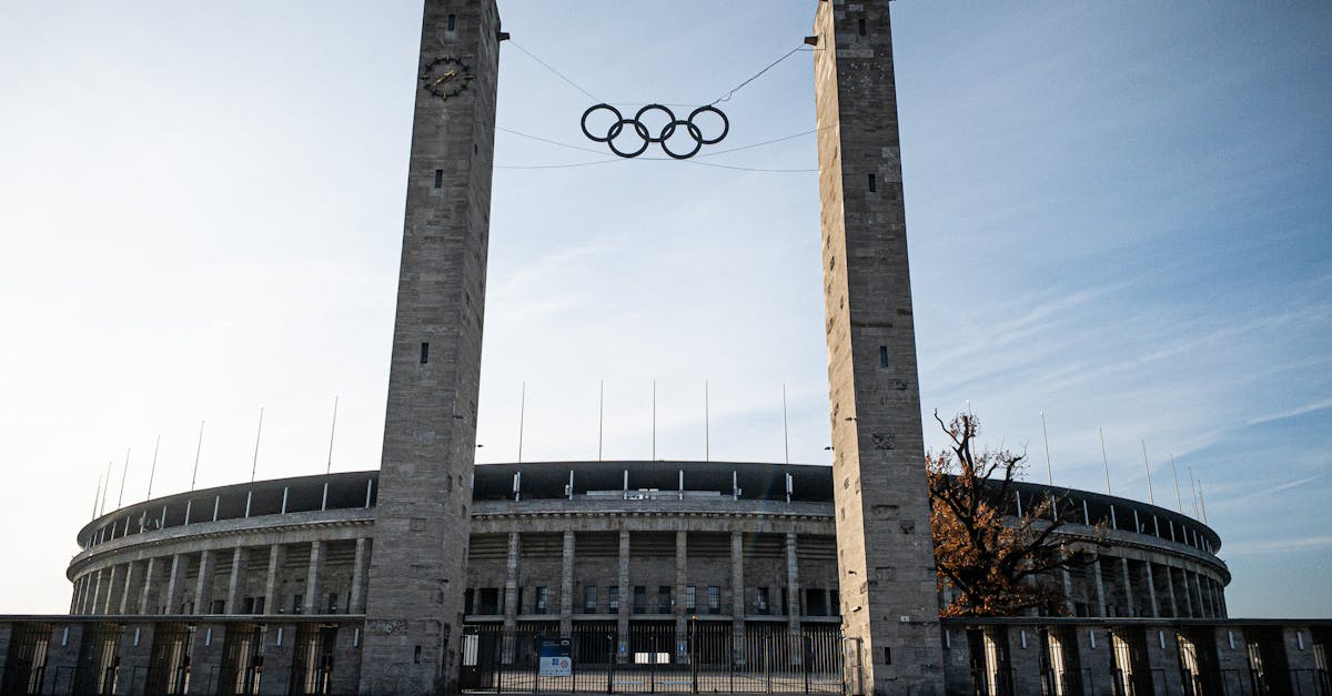 Poster design from 1936 Berlin Summer Olympics showing athlete, rings, and Brandenburg Gate